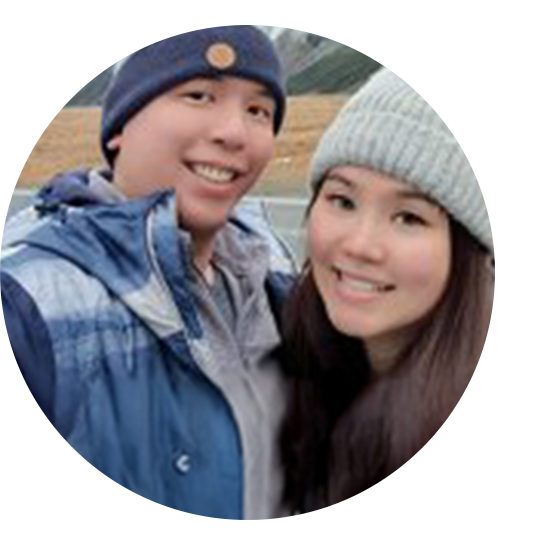 A woman wearing a sensor and holding her child in front of a fountain.