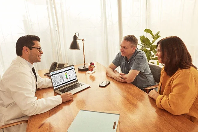 Pessoas em um consultório observando e discutindo os dados de um relatório gerado através da plataforma LibreView