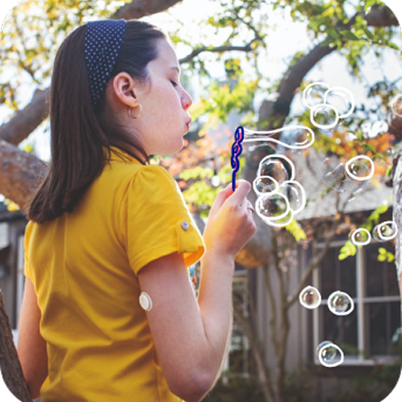 Illustration of a child blowing bubbles outdoors, wearing a CGM sensor on the upper arm.