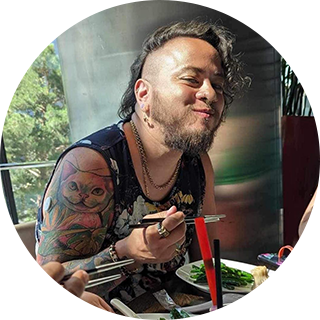 A man with tatoos wearing a sensor while eating.