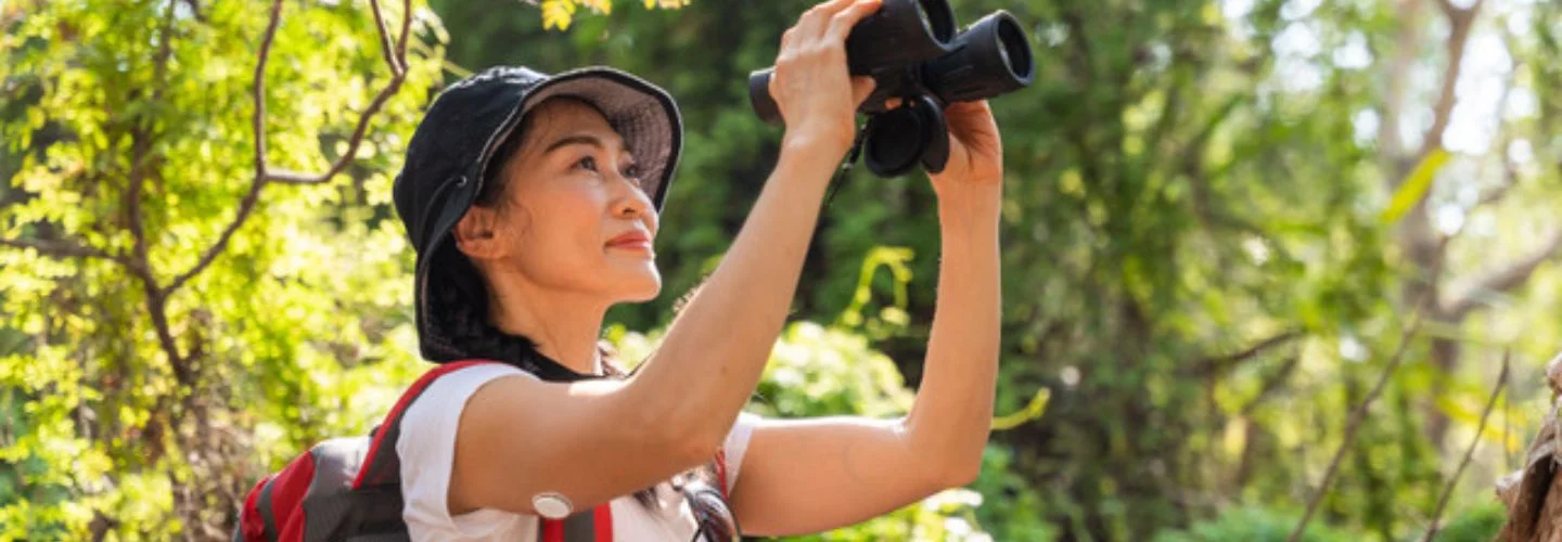 Woman in nature looking through binoculus