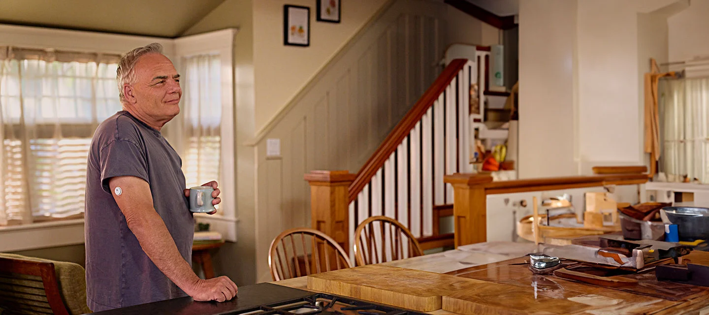 A man wearing a FreeStyle Libre sensor enjoying his morning coffee.