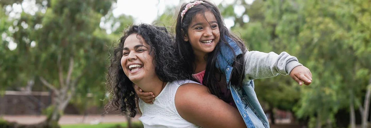Mother carrying her daughter on her back