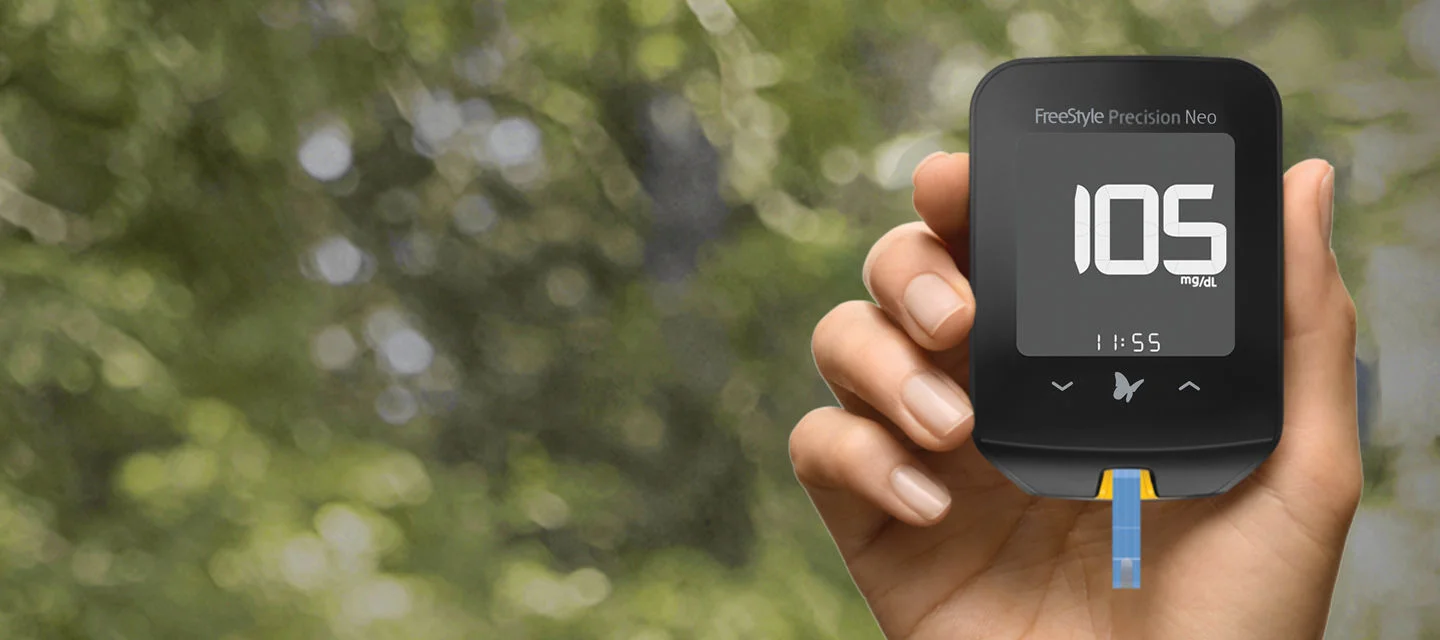 A hand holding a FreeStyle Precision Neo BGM.