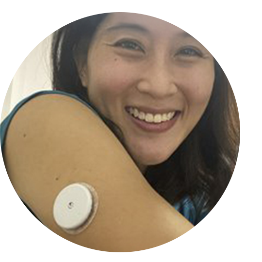 A woman wearing a sensor while standing in front of a prop plane.