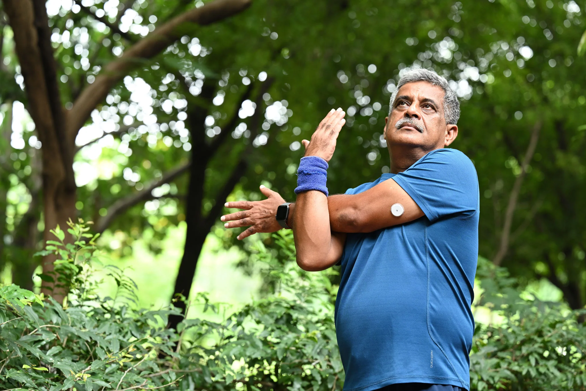 A man stretching outside wearing sensor
