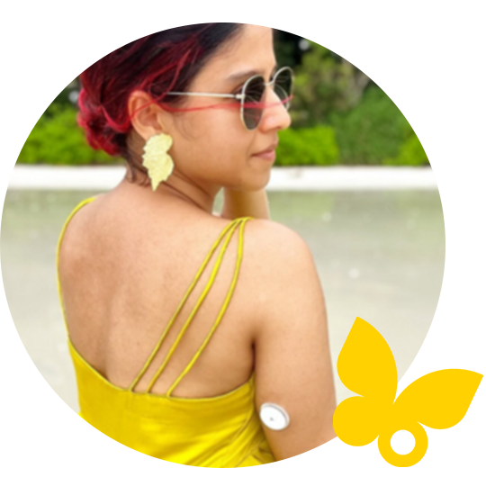 Lady in sun dress wearing a hat and FreeStyle Libre sensor