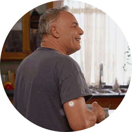 Animated image of a person wearing a CGM sensor on the upper arm while standing in a kitchen., and Child holding a football on a sports field while wearing a FreeStyle Libre 3 Plus sensor on the upper arm.