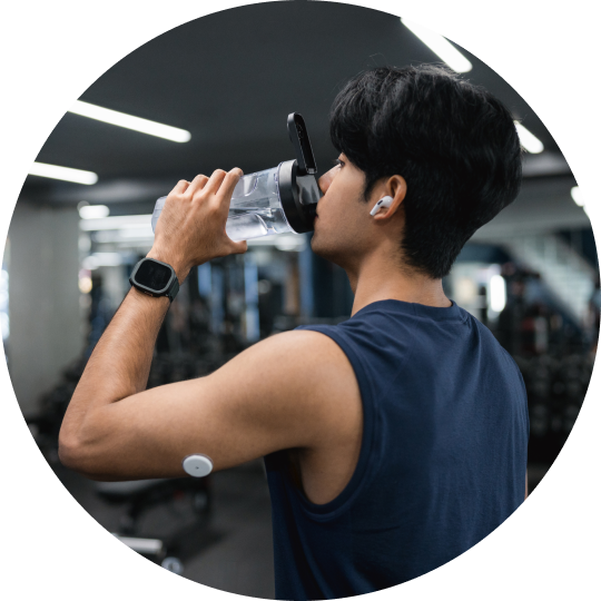  Hombre bebiendo agua en un gimnasio usando un sensor.