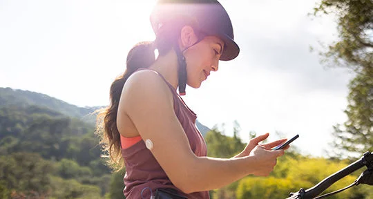 Læge viser data på skærm til patient med sensor på armen