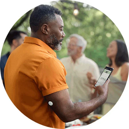 Man checking his phone while wearing a FreeStyle Libre 3 Plus sensor