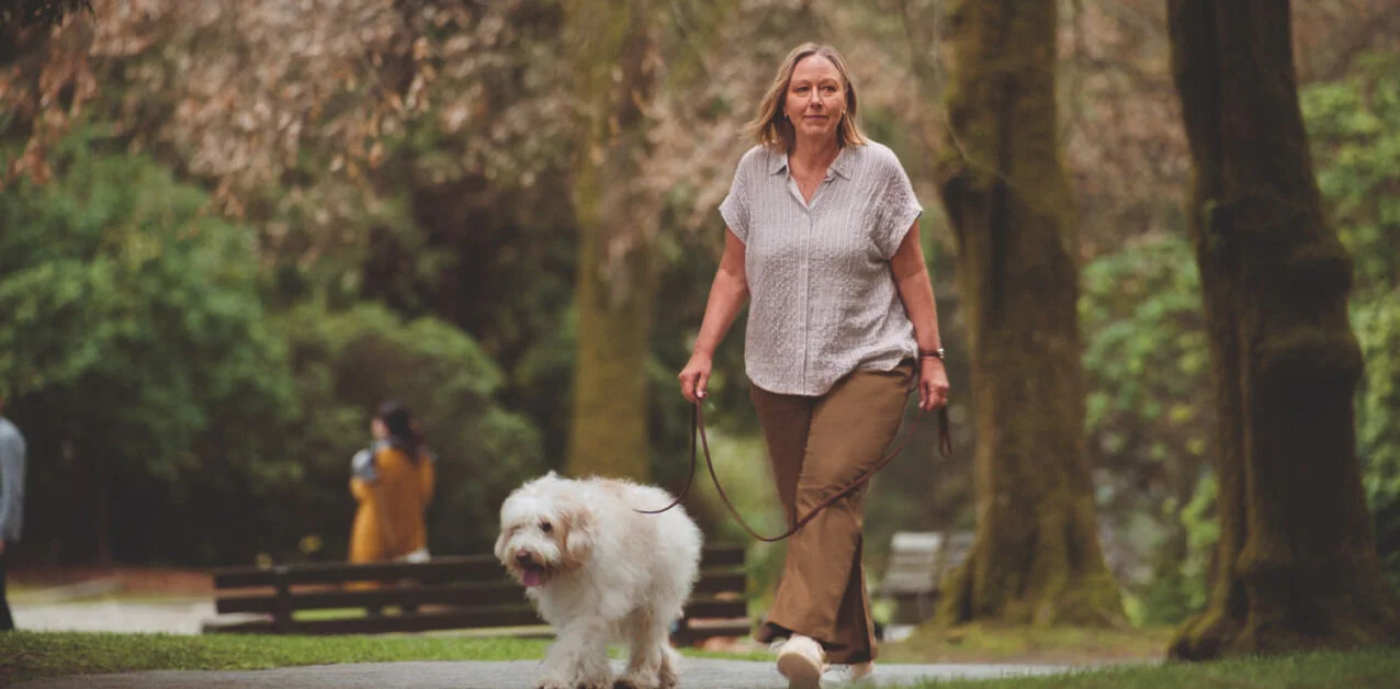 Persona caminando al aire libre para aliviar el estrés y cuidar su bienestar