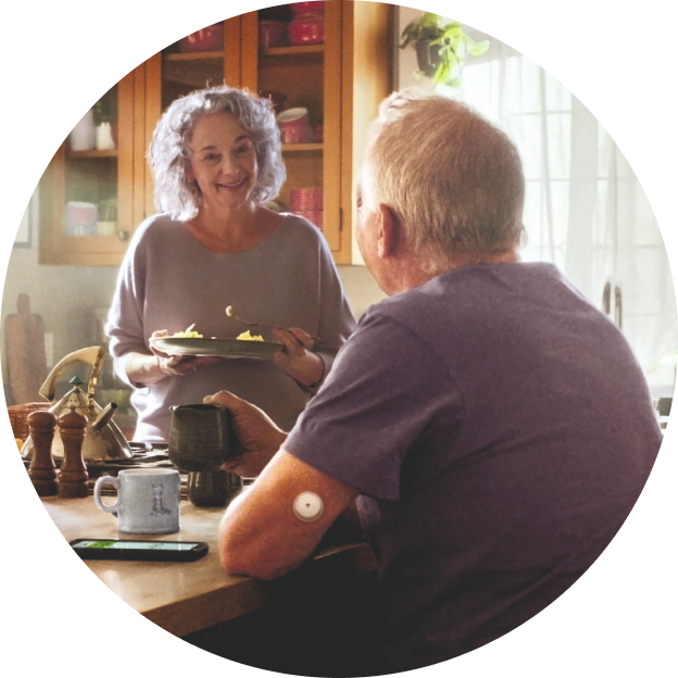 Esposa preparando el desayuno para su pareja, con alimentos frescos y nutritivos sobre la mesa