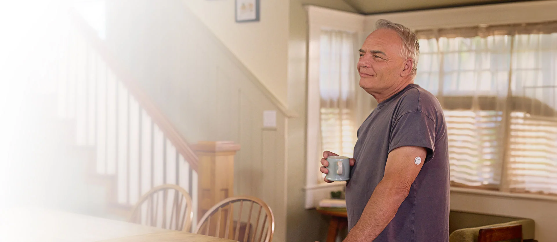 Man holding a cup while wearing a FreeStyle Libre 3 Plus sensor