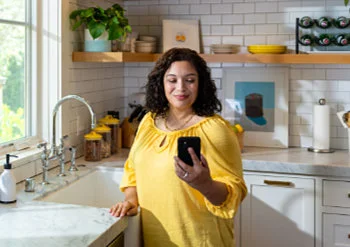 A man sitting on steps wearing a FreeStyle Libre sensor looking at his phone.
