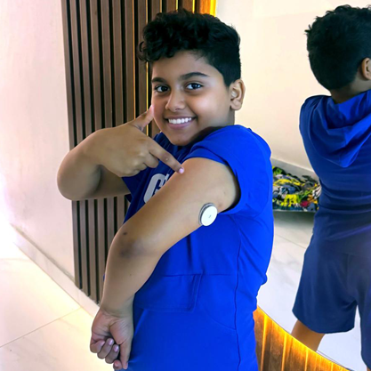 Boy pointing to the sensor on his arm