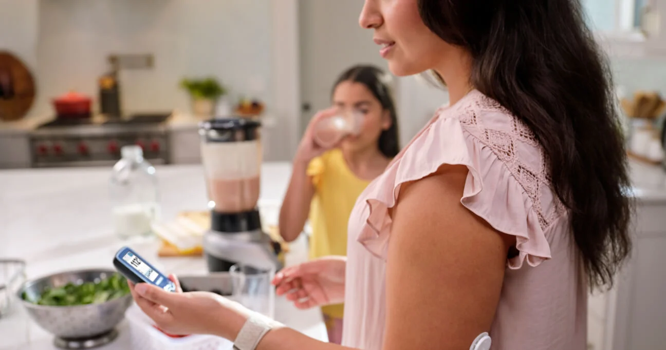 Madre e hija preparando un batido de frutos rojos en la cocina.
