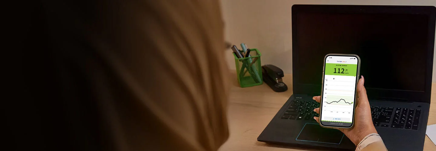 A woman looking at the Abbott  app splash screen on her phone.