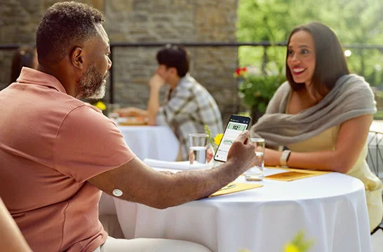 Man checking his phone while wearing a FreeStyle Libre 3 Plus sensor