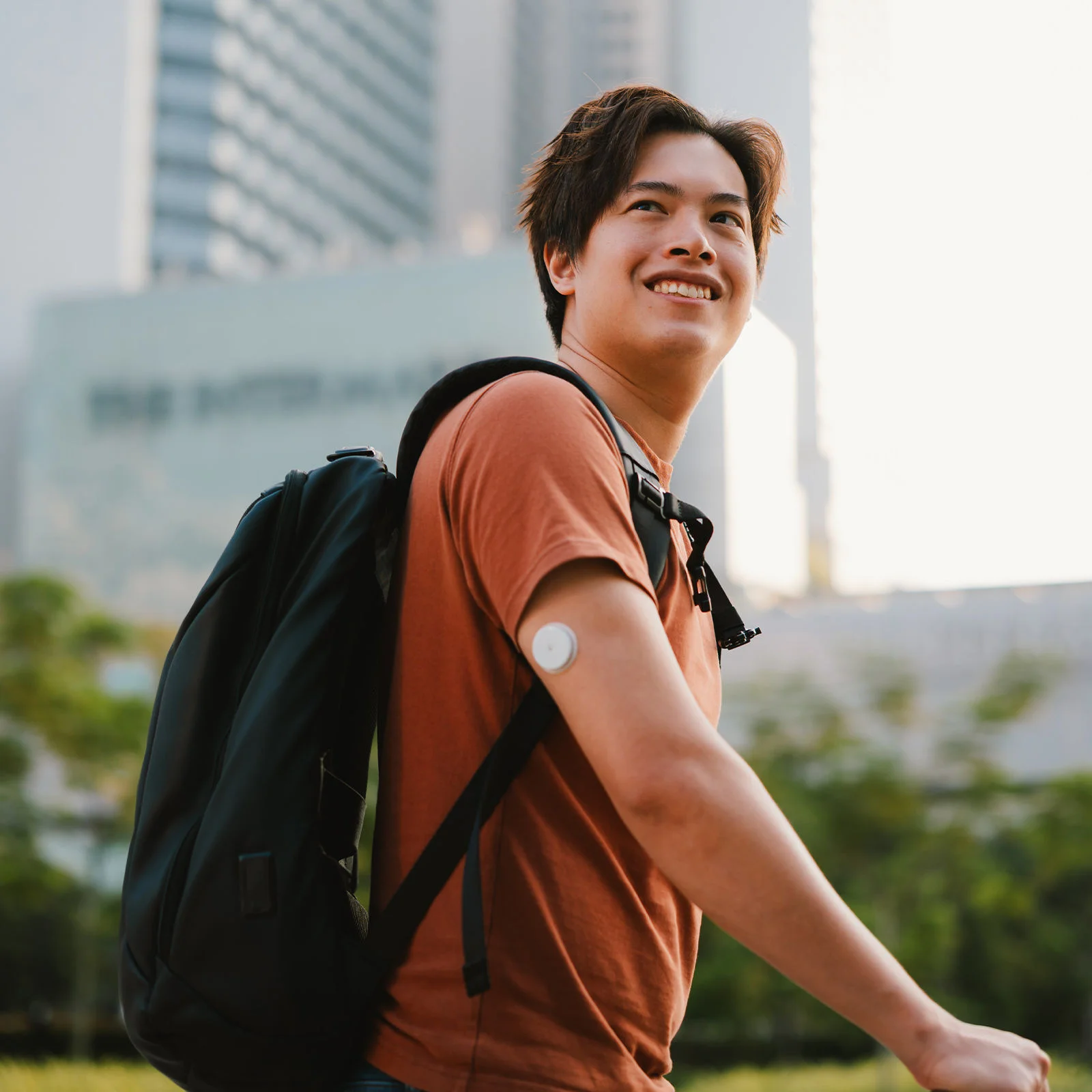 Person wearing a glucose sensor and backpack outdoors beside hyperglycemia information and diabetes education text.