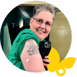 Woman with a tattoo wearing a FreeStyle Libre 3 Plus sensor