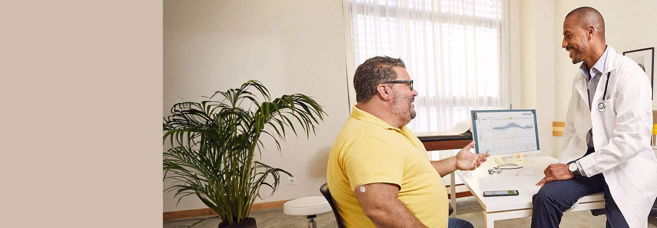 Man wearing FreeStyle Libre sensor talking with his doctor