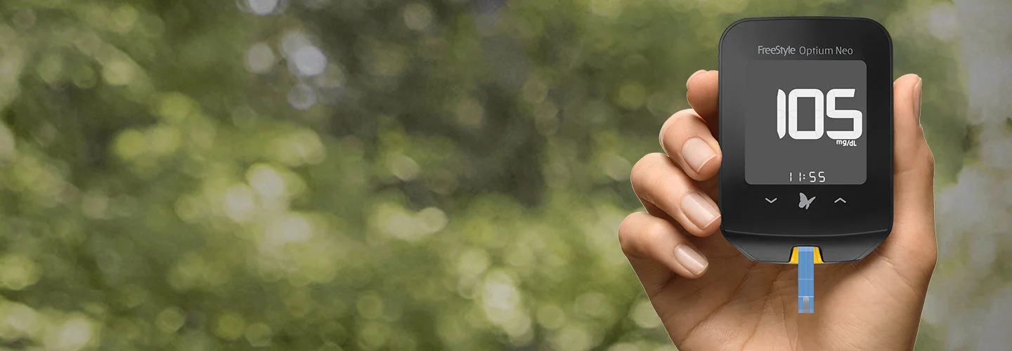 Hand holding FreeStyle Optium Neo