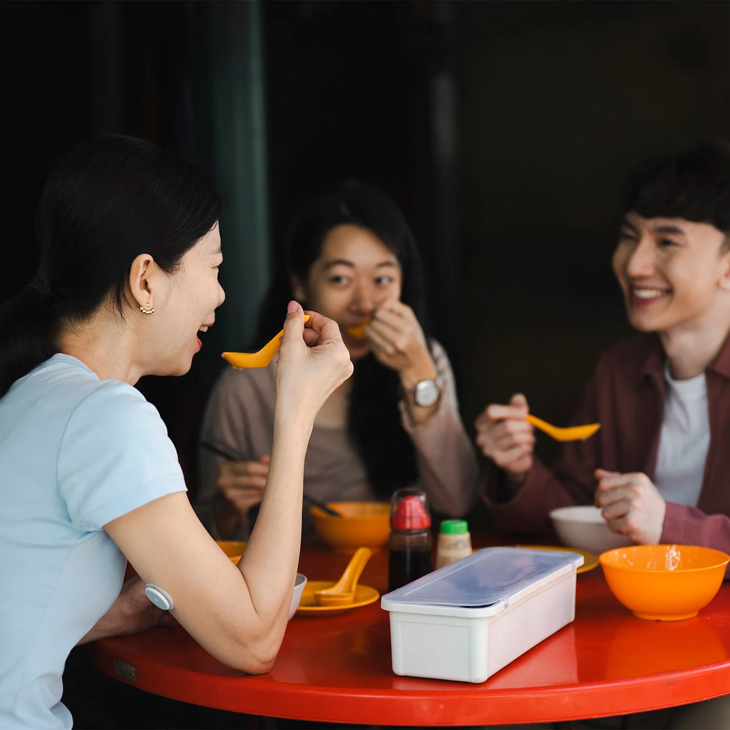 Smiling middle-aged couple at home shares a bowl of popcorn as a diabetes-friendly snack.