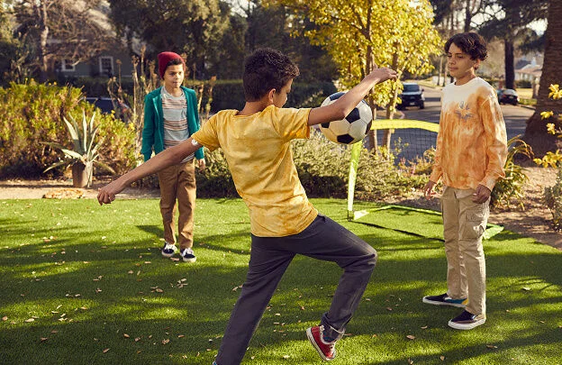 Niños jugando fútbol y disfrutando del momento mientras se mantienen activos.