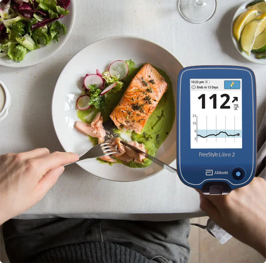  A healthy plate of salmon and pesto. Also includes image of a FreeStyle Libre 2 reader with data.