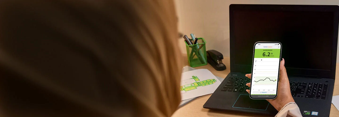 A woman looking at the Abbott  app splash screen on her phone.