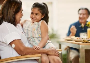 Grandmother hugging grandchild at dining table
