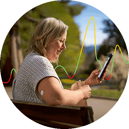 Woman looking at her phone while wearing a FreeStyle Libre 3 Plus sensor