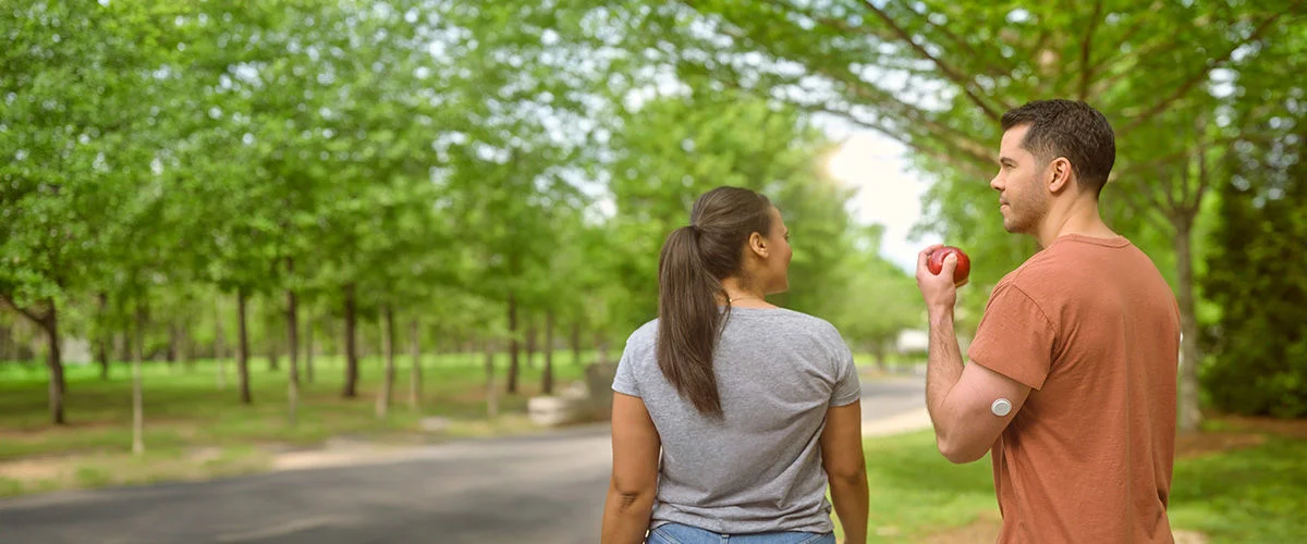 Casal andando em um parque arborizado