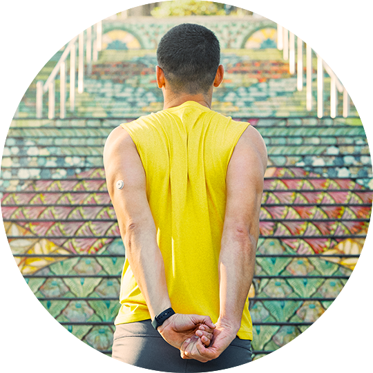 A man wearing a FreeStyle Libre sensor stretching outside.