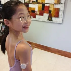 Young girl wearing FreeStyle Libre on her right arm