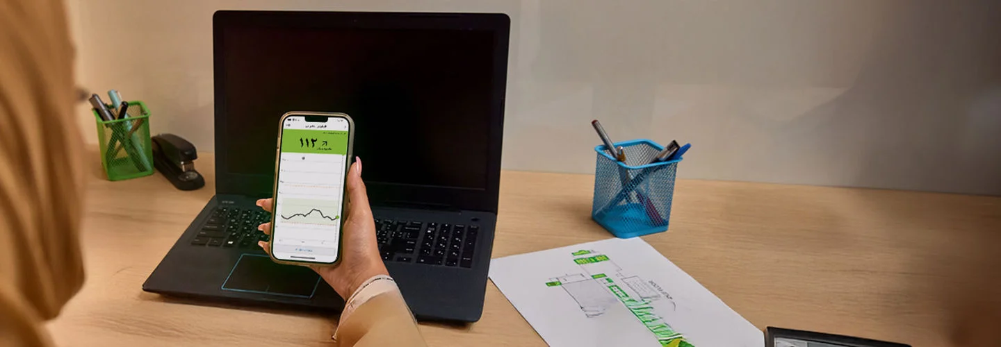   A woman looking at the Abbott  app splash screen on her phone.