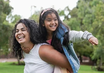 Mother carrying her daughter on her back