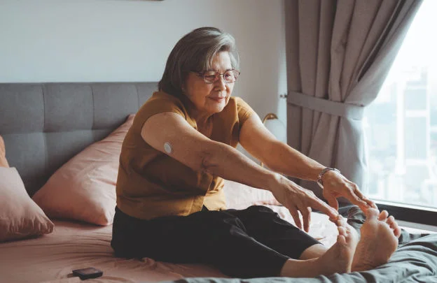 Senhora fazendo yoga na cama de forma relaxada