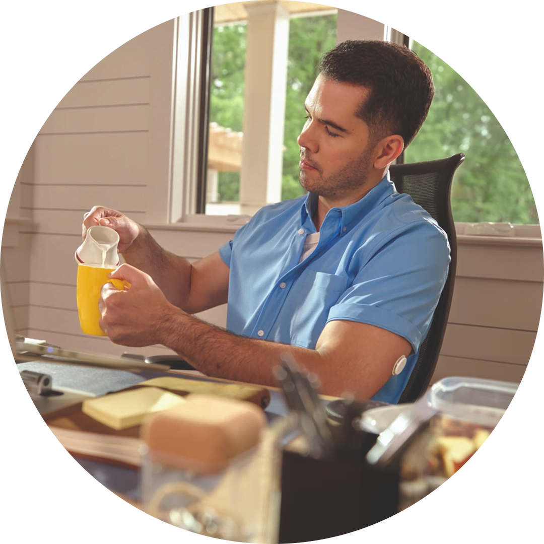 Person preparing food in a kitchen while wearing a FreeStyle Libre 2 glucose sensor, alongside text describing system features.