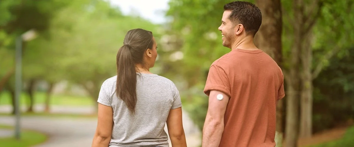 Casal andando em um parque arborizado