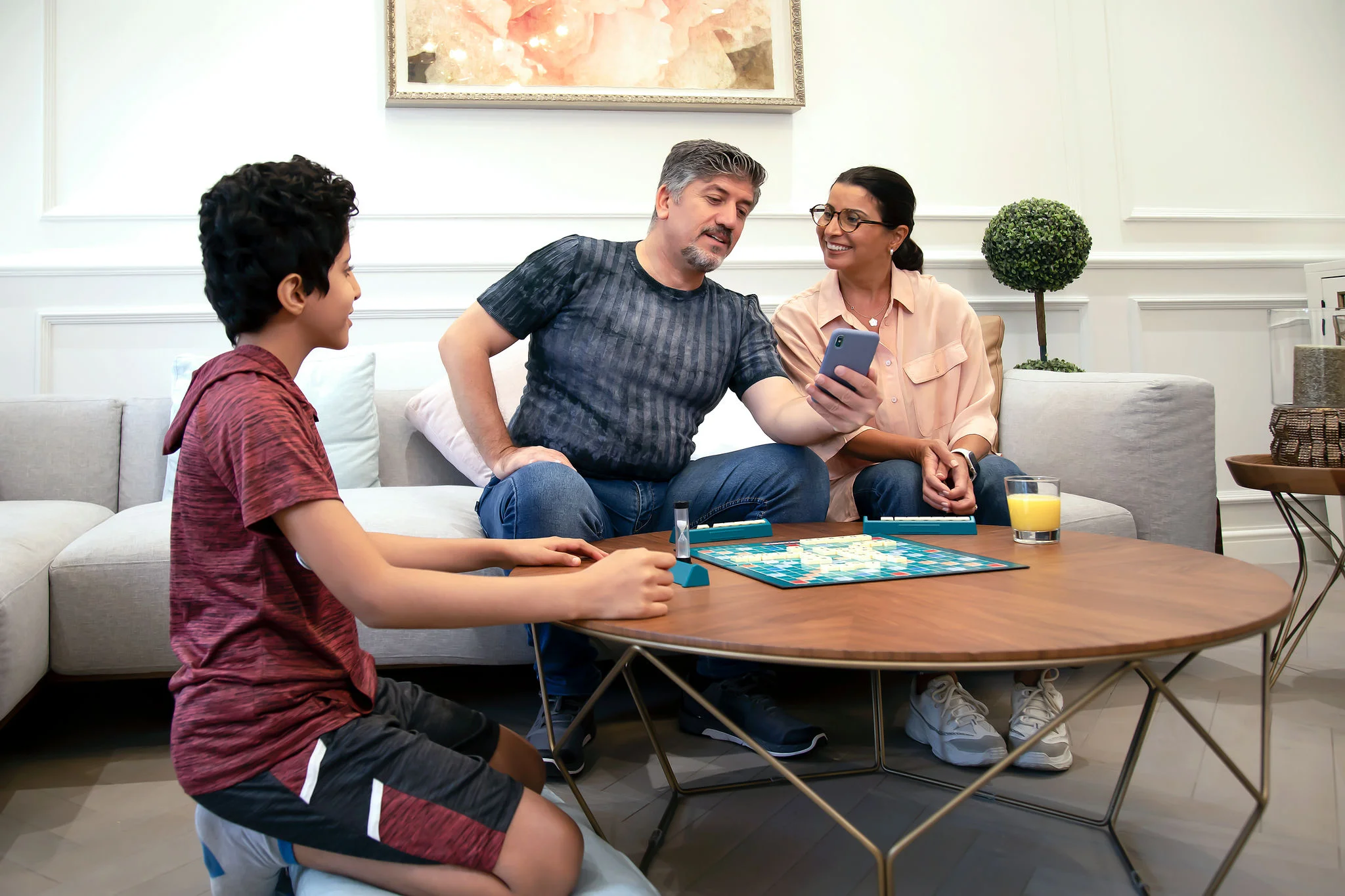 Pais verificando relatórios de glicose no celular enquanto a criança está presente, com o sensor FreeStyle Libre visível no braço.