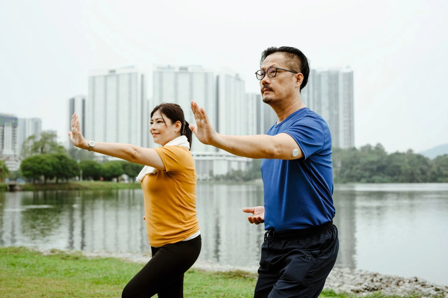 Two people doing tai chi in the park.