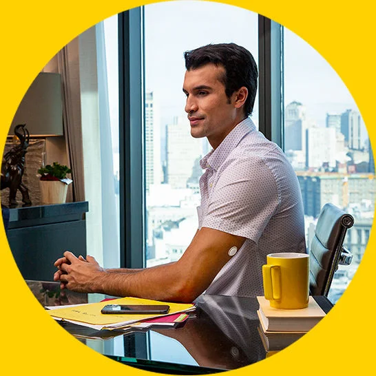 Man working at a desk while wearing a FreeStyle Libre systems sensor