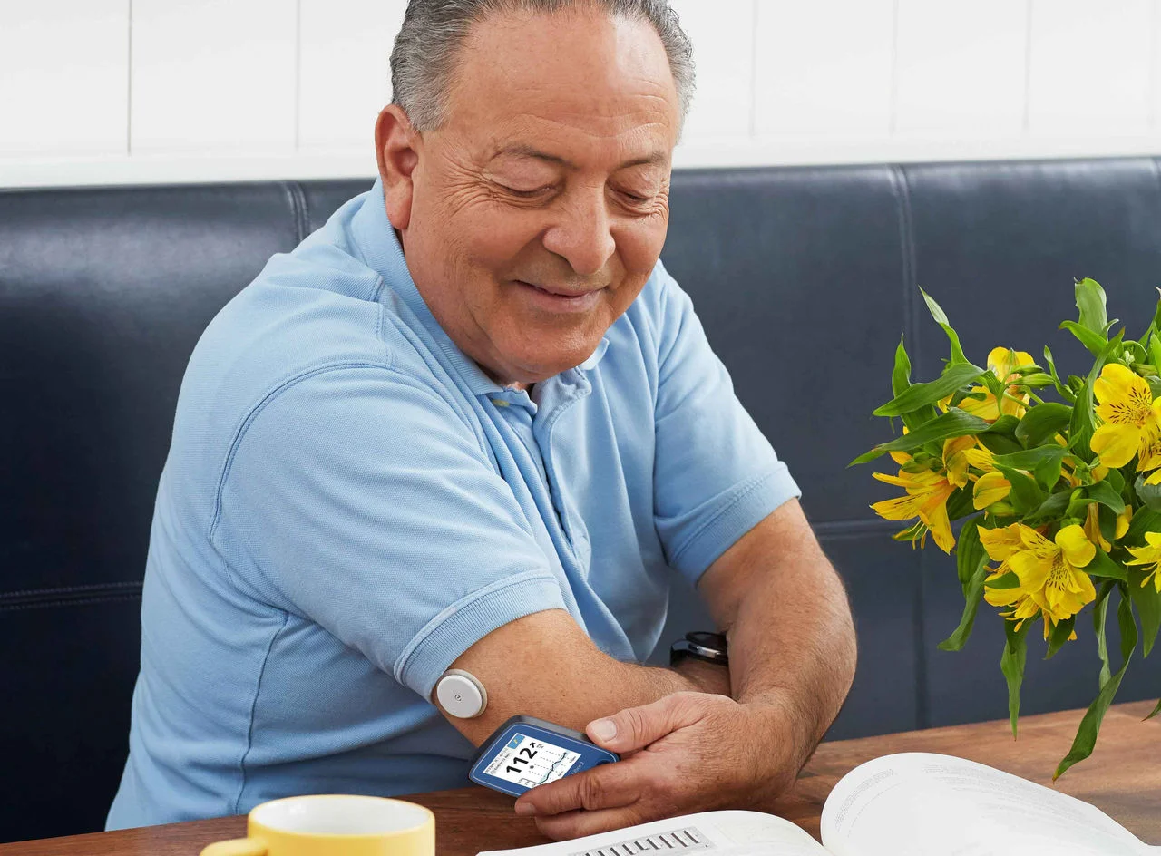 Man scanning FreeStyle Libre sensor with FreeStyle Libre 2 reader