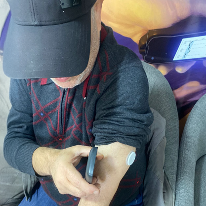 رجل يرتدي قبعة يأخذ القراءة من جهاز استشعار على ذراعه