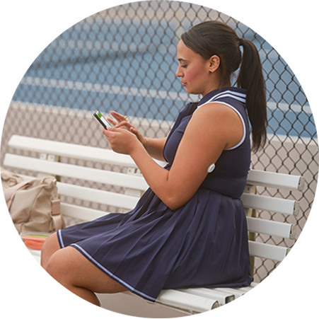 Woman checking her phone while wearing a FreeStyle Libre 2 Plus sensor