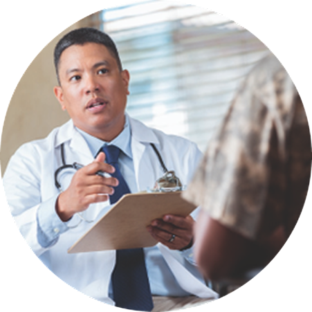Healthcare professional holding a clipboard and speaking with a patient during a medical consultation.