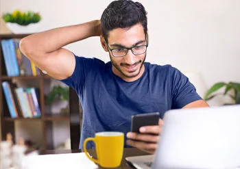  رجل يرتدي مستشعر FreeStyle Libre أثناء النظر إلى هاتفه.