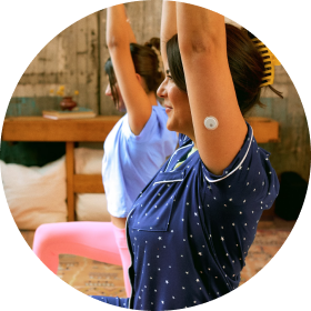 Woman doing yoga while wearing a FreeStyle Libre 3 Plus sensor